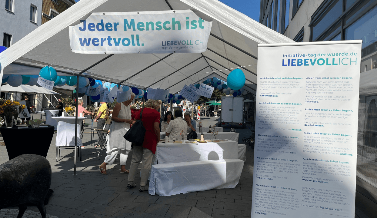 Tag der Würde – Aktionsstand mit blauem Schirm